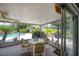 Enclosed patio featuring table, chairs, ceiling fan and view of the lush landscaping and pool area at 7902 Heather Ct, Tampa, FL 33634