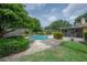 Backyard pool with lush landscaping, patio, and screened in porch at 7902 Heather Ct, Tampa, FL 33634