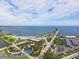 An aerial view of a pier extending into the ocean, surrounded by lush greenery and a sandy beach on a sunny day at 100 Beach Ne Dr # 301, St Petersburg, FL 33701