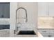 Close up of the kitchen sink with a modern faucet, granite countertops, and white cabinets at 100 Beach Ne Dr # 301, St Petersburg, FL 33701