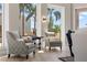 Living room with patterned chairs and large windows showcasing palm tree views at 100 Beach Ne Dr # 301, St Petersburg, FL 33701
