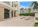 Inviting outdoor patio with striped lounge chairs, brick flooring and well-maintained landscaping at 100 Beach Ne Dr # 301, St Petersburg, FL 33701