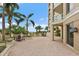 Expansive patio with brick pavers and outdoor seating with palm trees and a water view at 100 Beach Ne Dr # 301, St Petersburg, FL 33701