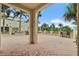 Expansive outdoor patio with palm trees, brick flooring, and lounge seating surrounded by manicured greenery at 100 Beach Ne Dr # 301, St Petersburg, FL 33701