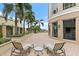 Exterior view of a large patio with lounge seating, brick flooring, and manicured landscaping, offering a relaxing outdoor space at 100 Beach Ne Dr # 301, St Petersburg, FL 33701