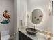 Stylish powder room boasts unique vanity, elegant mirror, and decorative accents at 100 Beach Ne Dr # 301, St Petersburg, FL 33701