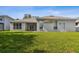 A back view of the home featuring a covered patio and green lawn at 10244 Shadow Branch Dr, Tampa, FL 33647