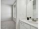 Bright bathroom featuring white vanity, stylish mirror, modern lighting, and open doorway to an adjacent room at 10244 Shadow Branch Dr, Tampa, FL 33647
