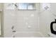 Bright bathroom features a bathtub with shower and tiled walls at 10244 Shadow Branch Dr, Tampa, FL 33647