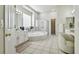 Bright bathroom with soaking tub, glass shower, white cabinets, and dual mirrors at 10244 Shadow Branch Dr, Tampa, FL 33647
