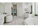 Bright bathroom with soaking tub, white vanity, and access to main bedroom at 10244 Shadow Branch Dr, Tampa, FL 33647
