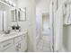 Bright bathroom featuring white vanity, stylish mirrors, modern lighting, and open doorway to bath and toilet at 10244 Shadow Branch Dr, Tampa, FL 33647