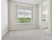 Bright bedroom features a large window overlooking lush landscaping and an ensuite bath at 10244 Shadow Branch Dr, Tampa, FL 33647