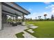 Modern clubhouse patio with sleek furniture, artificial turf, and space for outdoor games at 10244 Shadow Branch Dr, Tampa, FL 33647