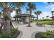 Beautiful community clubhouse featuring an outdoor fireplace, tables, and lush tropical landscaping at 10244 Shadow Branch Dr, Tampa, FL 33647