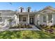 Inviting front porch with pillars and a landscaped garden leading to a stylish glass front door at 10244 Shadow Branch Dr, Tampa, FL 33647