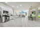 Open concept kitchen and living area with tile flooring, white cabinets, and stainless appliances at 10244 Shadow Branch Dr, Tampa, FL 33647
