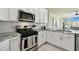 Updated kitchen showcases modern appliances, white cabinets, and granite countertops at 10244 Shadow Branch Dr, Tampa, FL 33647
