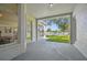Covered patio overlooking a green lawn and tall trees, adjacent to dining room at 10244 Shadow Branch Dr, Tampa, FL 33647