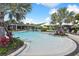 A large luxurious resort style pool surrounded by tropical plants and resort-style furniture at 10244 Shadow Branch Dr, Tampa, FL 33647