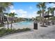 Community pool surrounded by lounge chairs, palm trees, and beautiful landscaping at 10244 Shadow Branch Dr, Tampa, FL 33647