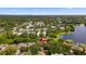 Aerial view showcasing the home's location near a serene lake and lush greenery, with a city skyline in the distance at 10310 Carroll Cove Pl, Tampa, FL 33612