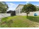 Spacious backyard featuring a screened porch, white fence, and lush green lawn at 10310 Carroll Cove Pl, Tampa, FL 33612
