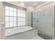 Modern bathroom features a soaking tub, frameless glass shower, and marble tile at 10310 Carroll Cove Pl, Tampa, FL 33612