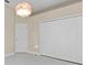 Bedroom with closet and white door, plus a unique light fixture and tile floors at 10310 Carroll Cove Pl, Tampa, FL 33612