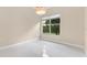 Neutral bedroom featuring a modern light fixture and large window providing natural light at 10310 Carroll Cove Pl, Tampa, FL 33612