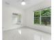 Bright bedroom with large window and neutral walls, mirror accent and marble floor at 10310 Carroll Cove Pl, Tampa, FL 33612