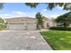 Charming home featuring a three-car garage, stone accents, a brick driveway, and well-manicured lawn at 10310 Carroll Cove Pl, Tampa, FL 33612