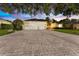 Exterior view of a home with a three-car garage and long paved driveway at 10310 Carroll Cove Pl, Tampa, FL 33612