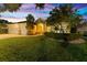 Charming home with lush lawn, stone pillars, and a multi-car garage, set against a twilight sky at 10310 Carroll Cove Pl, Tampa, FL 33612