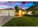Inviting home featuring a well-manicured lawn, stone accents, and a grand entrance with ample parking at 10310 Carroll Cove Pl, Tampa, FL 33612