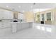 Open kitchen with white cabinetry, marble countertops, stainless steel appliances, and an adjoining dining area at 10310 Carroll Cove Pl, Tampa, FL 33612