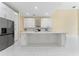 Spacious kitchen with white cabinets, stainless steel appliances, marble countertops, and large center island at 10310 Carroll Cove Pl, Tampa, FL 33612