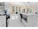 Modern kitchen boasts white cabinets, marble countertops, stainless steel appliances, and a view to the living area at 10310 Carroll Cove Pl, Tampa, FL 33612