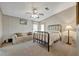 Comfortable bedroom featuring a metal frame bed, ceiling fan, sofa, and carpet flooring at 106 N Saint George Cir, Apollo Beach, FL 33572