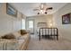 Comfortable bedroom featuring a metal frame bed, ceiling fan, sofa, and carpet flooring at 106 N Saint George Cir, Apollo Beach, FL 33572