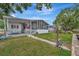 Charming home with a screened-in porch, complemented by a well-manicured lawn and mature trees at 106 N Saint George Cir, Apollo Beach, FL 33572