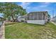 Exterior view of home showcasing a spacious screened-in porch and landscaped yard with mature trees at 106 N Saint George Cir, Apollo Beach, FL 33572