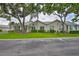 Inviting single-story home with lush green lawn and mature trees offering shade and curb appeal at 1111 Golfview Woods Dr # 1111, Sun City Center, FL 33573