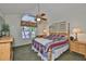 Bright main bedroom featuring a wooden bed frame, ceiling fan, and a large window at 1111 Golfview Woods Dr # 1111, Sun City Center, FL 33573