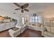 Cozy living room with hardwood floors, neutral furniture, ceiling fan, and stylish nautical decor at 1224 W Del Webb Blvd, Sun City Center, FL 33573