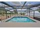 Screened-in pool area with waterfall feature, and a view of the lush backyard and surrounding landscape at 1224 W Del Webb Blvd, Sun City Center, FL 33573