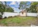 Backyard featuring a storage shed with a bench in a grassy area bordered by a white privacy fence at 12306 91St Ter, Seminole, FL 33772