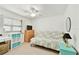 Cozy bedroom with a ceiling fan, dresser, and a comfortable futon near a bright window at 12306 91St Ter, Seminole, FL 33772
