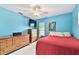 A bright bedroom featuring blue walls, wood furniture, and a red bedspread at 12306 91St Ter, Seminole, FL 33772