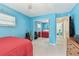 Cozy bedroom with bright blue walls, mirrored closet doors, and a glimpse into the hallway at 12306 91St Ter, Seminole, FL 33772